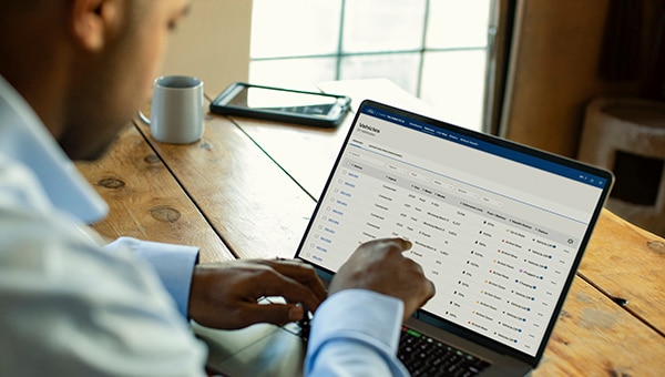 Prise de vue par-dessus l’épaule d’un homme pointant en direction de l’écran de son ordinateur portable
