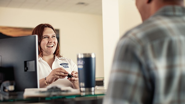 Image présentant une femme membre de l’équipe Ford Pro derrière un bureau et une tasse à café