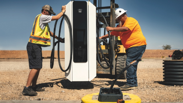 Two workers installing a new charging station