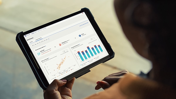 Vue de l’arrière d’une femme qui travaille sur une tablette affichant le logiciel E-Telematics de Ford Pro.