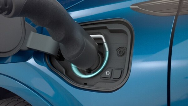 Gros plan d’une borne de recharge branchée sur un véhicule.