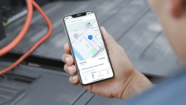 A person holding a phone with a map image on its screen.