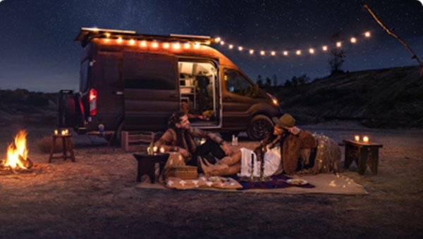 Two campers using their E-transit for lights.