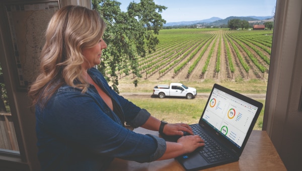 Une femme analyse le tableau de bord télématique où figurent les alertes sur l’état du véhicule et un calendrier