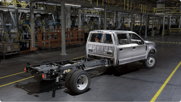 Un châssis de camion Ford de couleur argent sur une chaîne de montage.