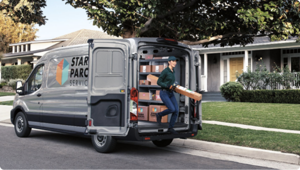 Un chauffeur-livreur sort d’une fourgonnette marquée au nom d’une compagnie lors d’une livraison commerciale.