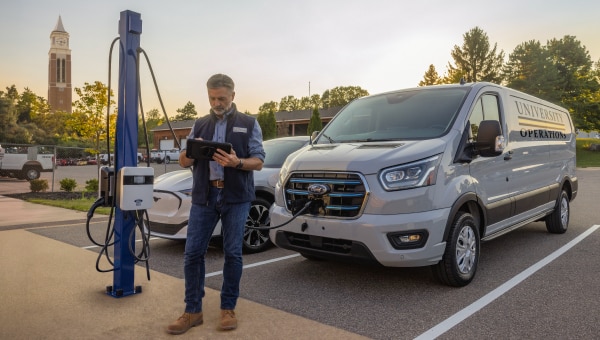 A man standing in front of an EV charger.