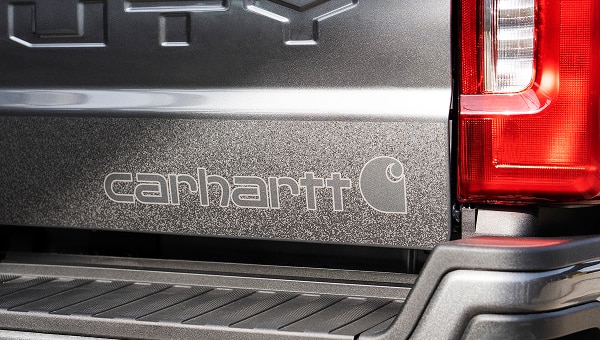 Gros plan sur le hayon du camion, orné d’un logo Carhartt en relief.