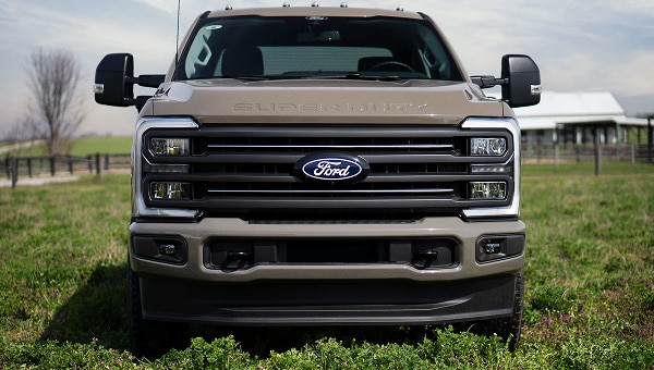 Vue de l’avant d’un Ford Super Duty 2027 de couleur havane, mettant en valeur la calandre et les phares caractéristiques en forme de serre en C.