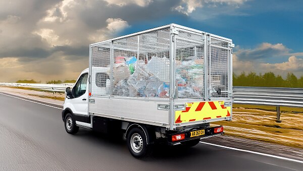 Přestavba Ford Transit s klecovou nástavbou naloženou odpadem k likvidaci.