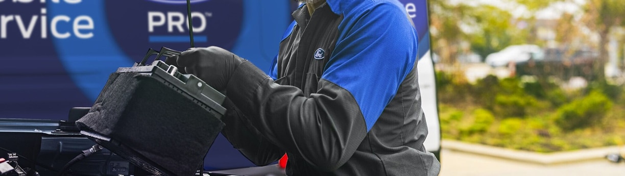 Técnico de Servicio Móvil Ford Pro realizando mantenimiento de motor en sitio.