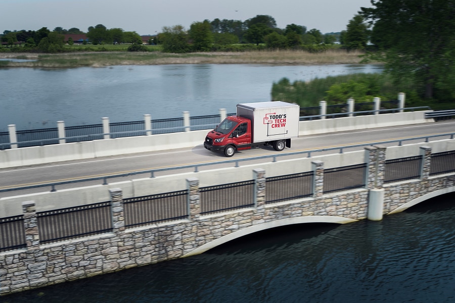 Ford Transit Chasis roja circulando sobre un Puente con carrocería de servicio.