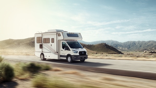 Casa rodante basada en Ford Transit circulando por carretera montañosa.