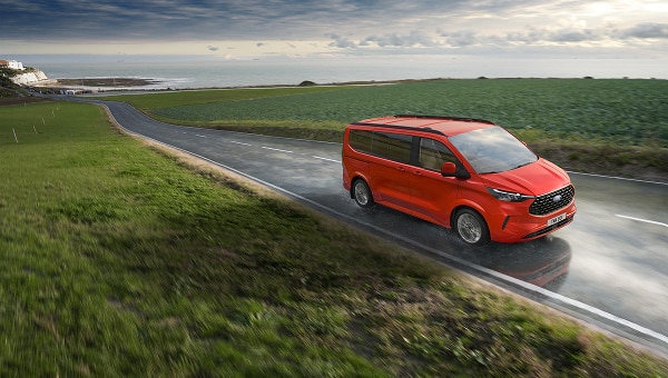 Ford Transit Custom roja circulando por carretera.