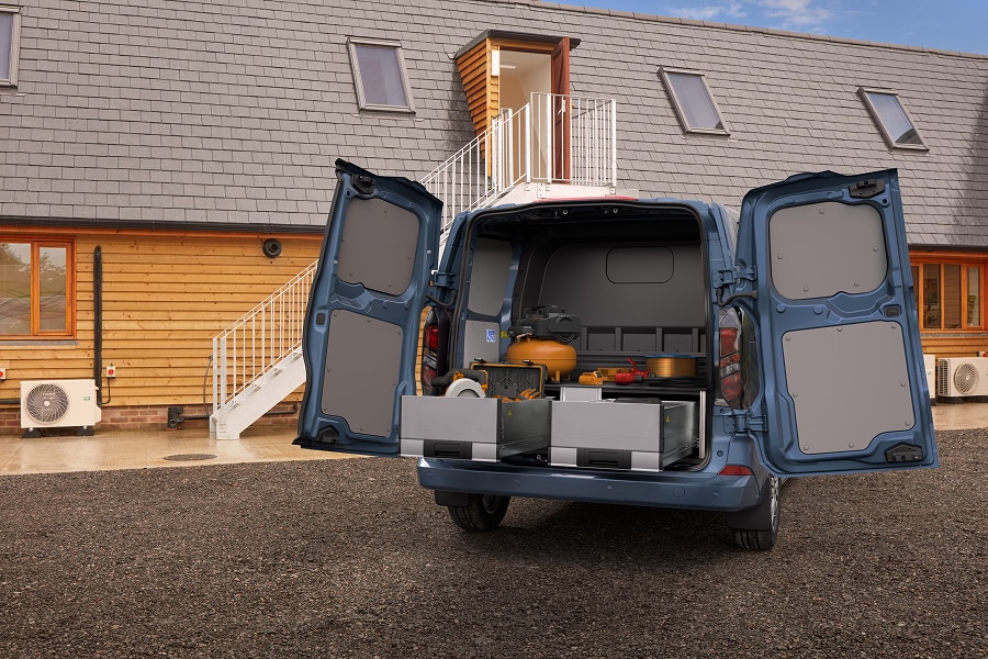 Ford Transit Custom azul con puertas traseras abiertas, mostrando un interior equipado con herramientas y almacenamiento modular.