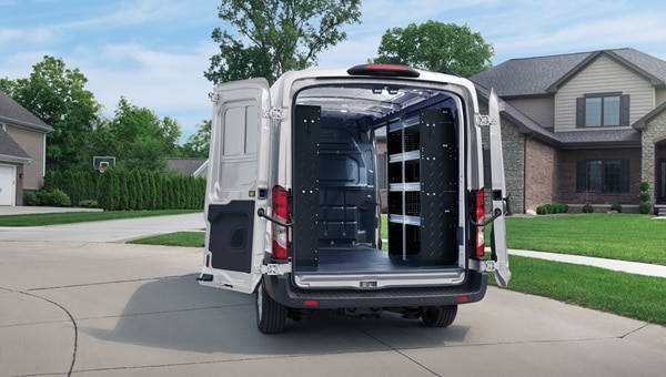 Ford Transit Van blanca con puertas traseras abiertas mostrando estanterías interiors.