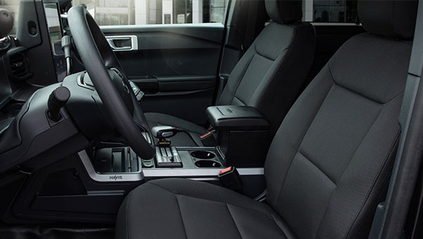 Interior de Ford Police Interceptor Híbrida, mostrando los asientos delanteros, junto con su volante y adaptado en su consola.