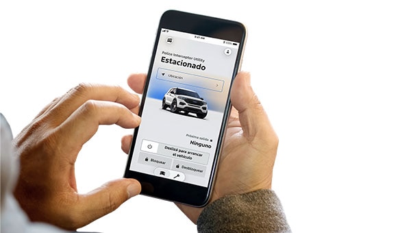 Unas manos sostienen un smartphone que muestra la aplicación FordPass con detalles de una Ford Police Interceptor Híbrida, incluyendo el nivel de combustible, estado del vehículo y opciones de control remoto.