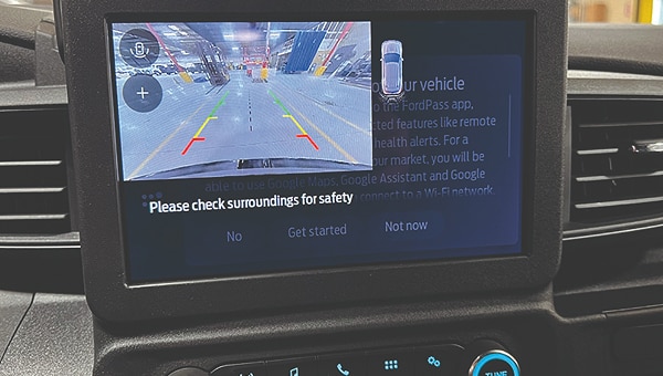 Pantalla táctil del sistema de infoentretenimiento de un Ford Police Interceptor, mostrando la vista de la cámara trasera con líneas guía.