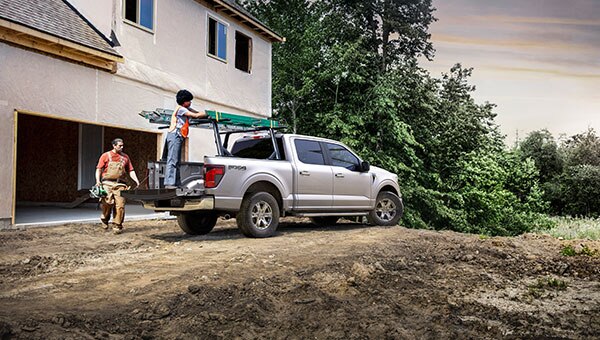 F-150 plata en camino de tierra mostrando sus capacidades de carga.