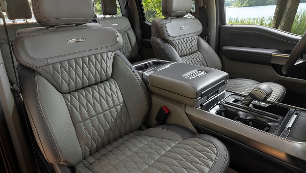 Interior de Ford Lobo 2026 con asientos de cuero gris acolchado y consola central.