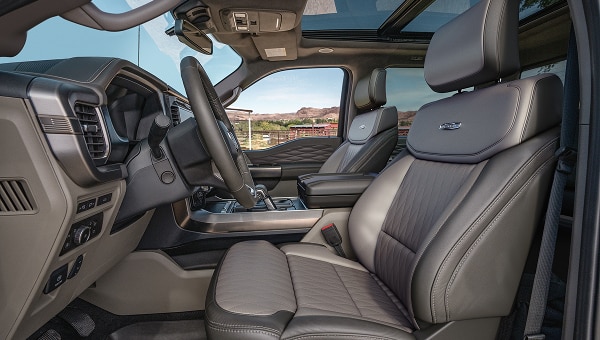 Interior de Ford Lobo 2026 mostrando el amplio espacio delantero, asientos de cuero y el techo panorámico Vista Roof.