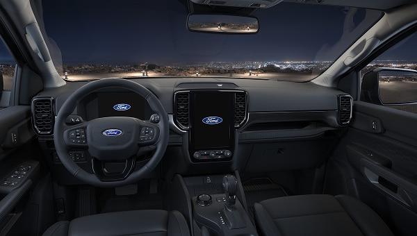 Interior de Ford Ranger 2026 de noche, mostrando tablero y pantallas digitales.