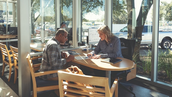 Two professionals meeting inside a café to discuss fleet operations and business solutions.