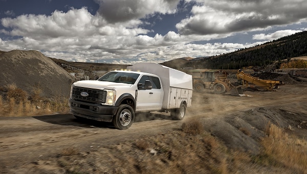 Ford Pro work truck driving through a rugged mining or quarry site.