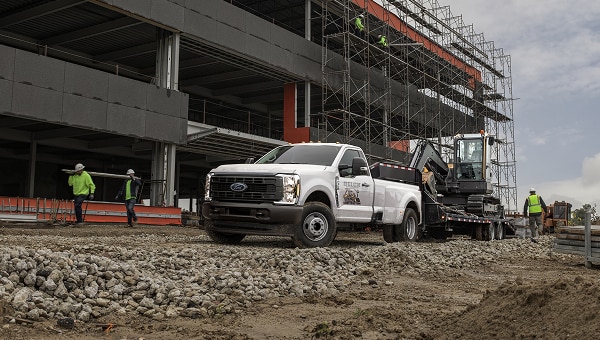 Ford Pro pickup truck at a commercial construction site with a building under development.