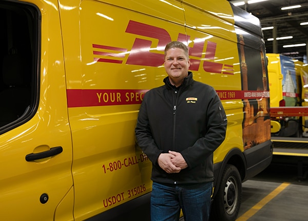 Man leaning against a DHL express van.