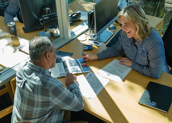 Ford Pro FinSimple financing expert helping a business owner in an office.