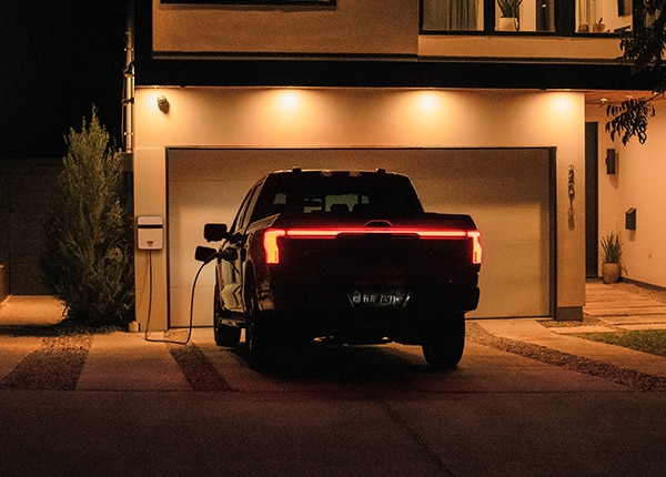 Ford F-150 Lightning plugged into a home charger.