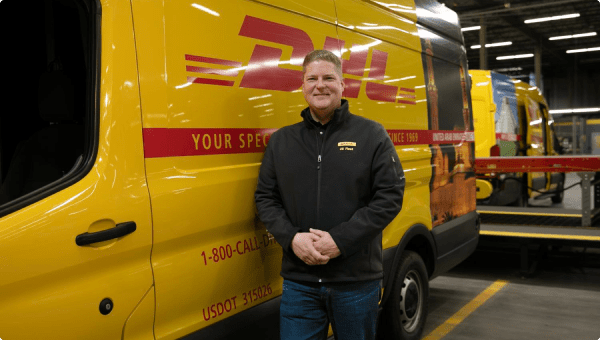 A man in front of a DHL-branded Ford Transit van.