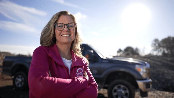 A woman in front of a Ford truck.