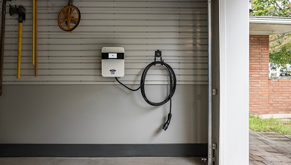 Ford Pro commercial EV charging station mounted on garage wall