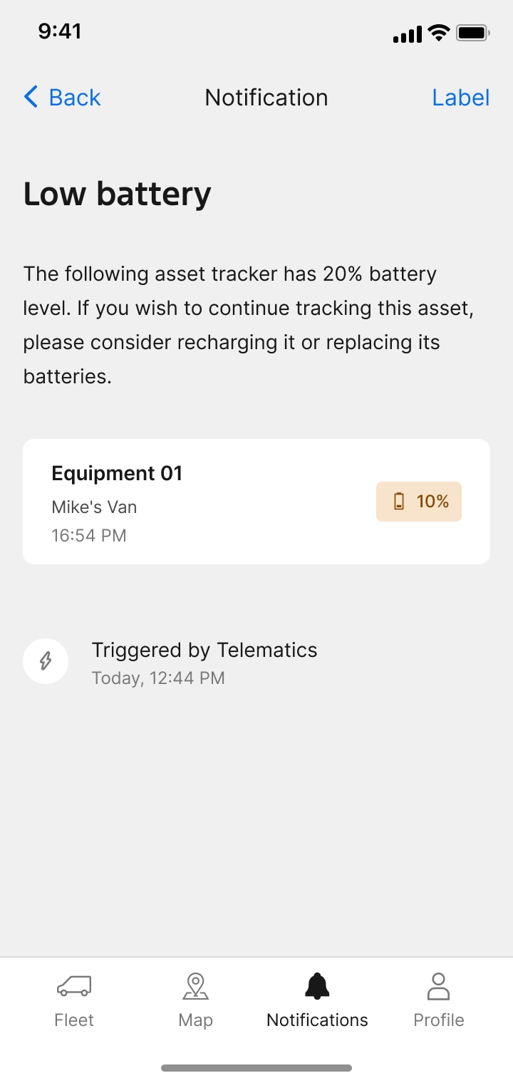 A mobile notification screen alerts the user that an asset tracker has a low 20% battery level and recommends recharging or replacing the batteries.