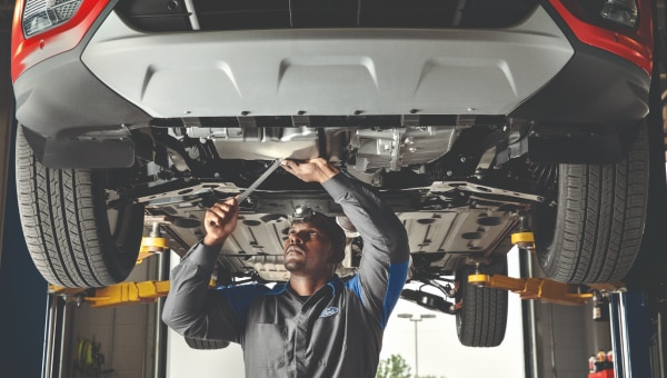 Technician working under a fleet vehicle at a Commercial Vehicle Center