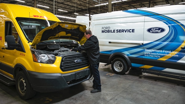 Service employee looking under the hood of a Ford Transit, diesel truck repair