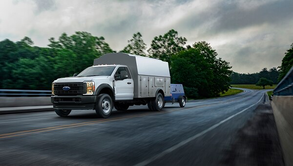 An upfitted Ford truck driving on a road.