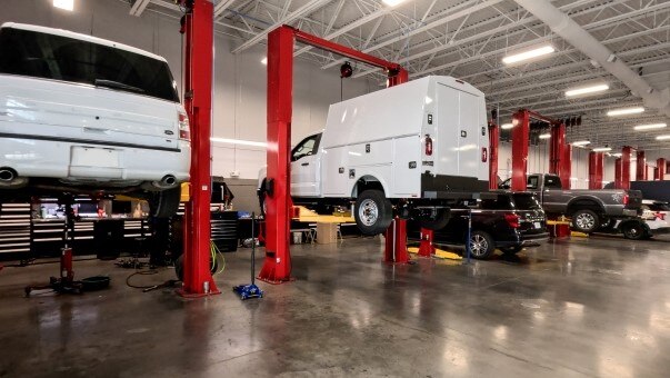 Ford commercial vehicles in an Elite Commercial Center service bay.