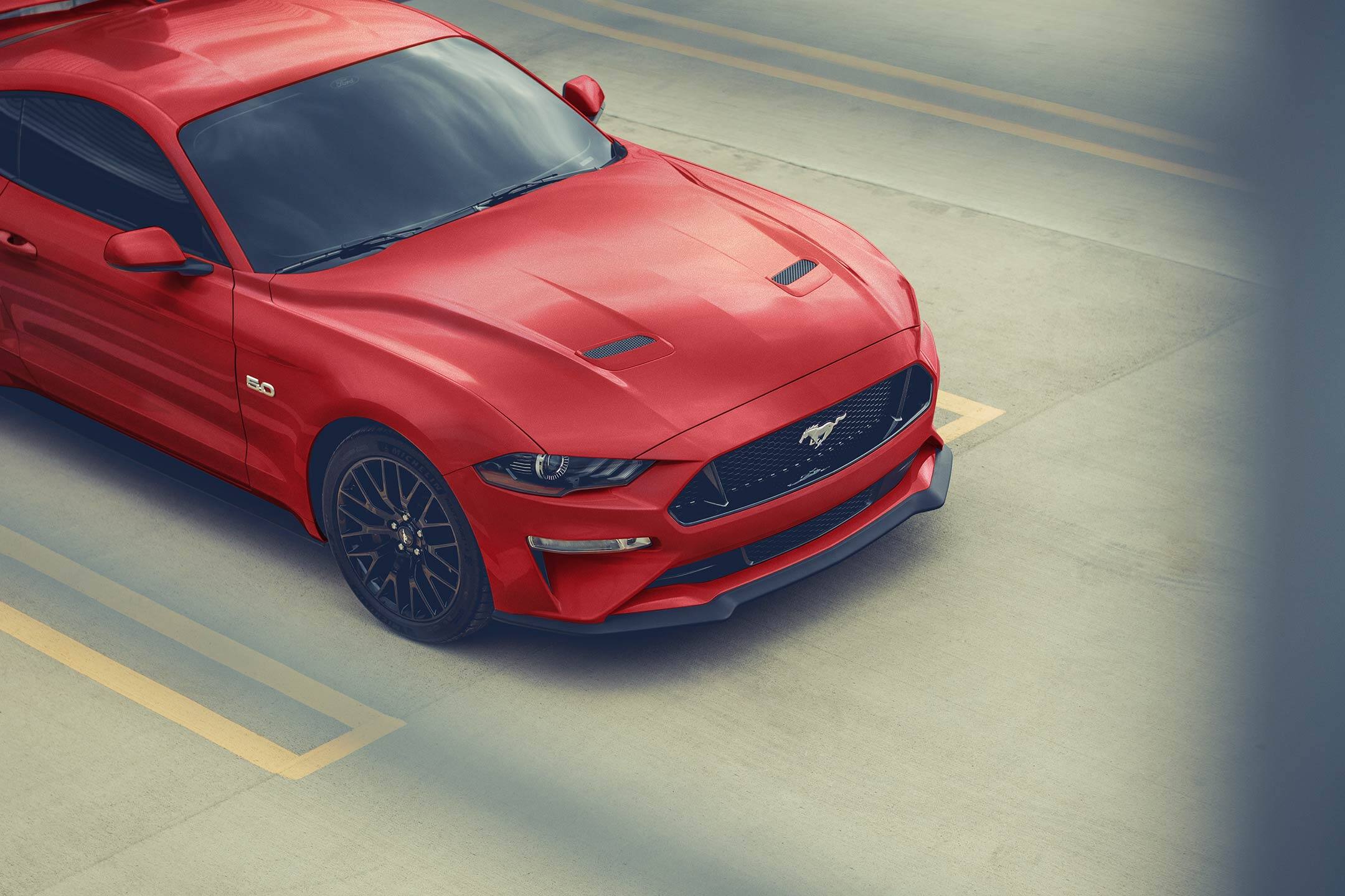 A 2023 Ford Mustang® coupe parked outside of a garage