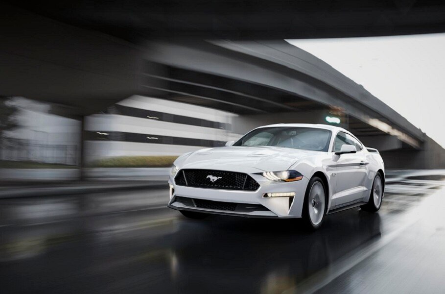 2023 Ford Mustang® coupe in Oxford White being driven down a street