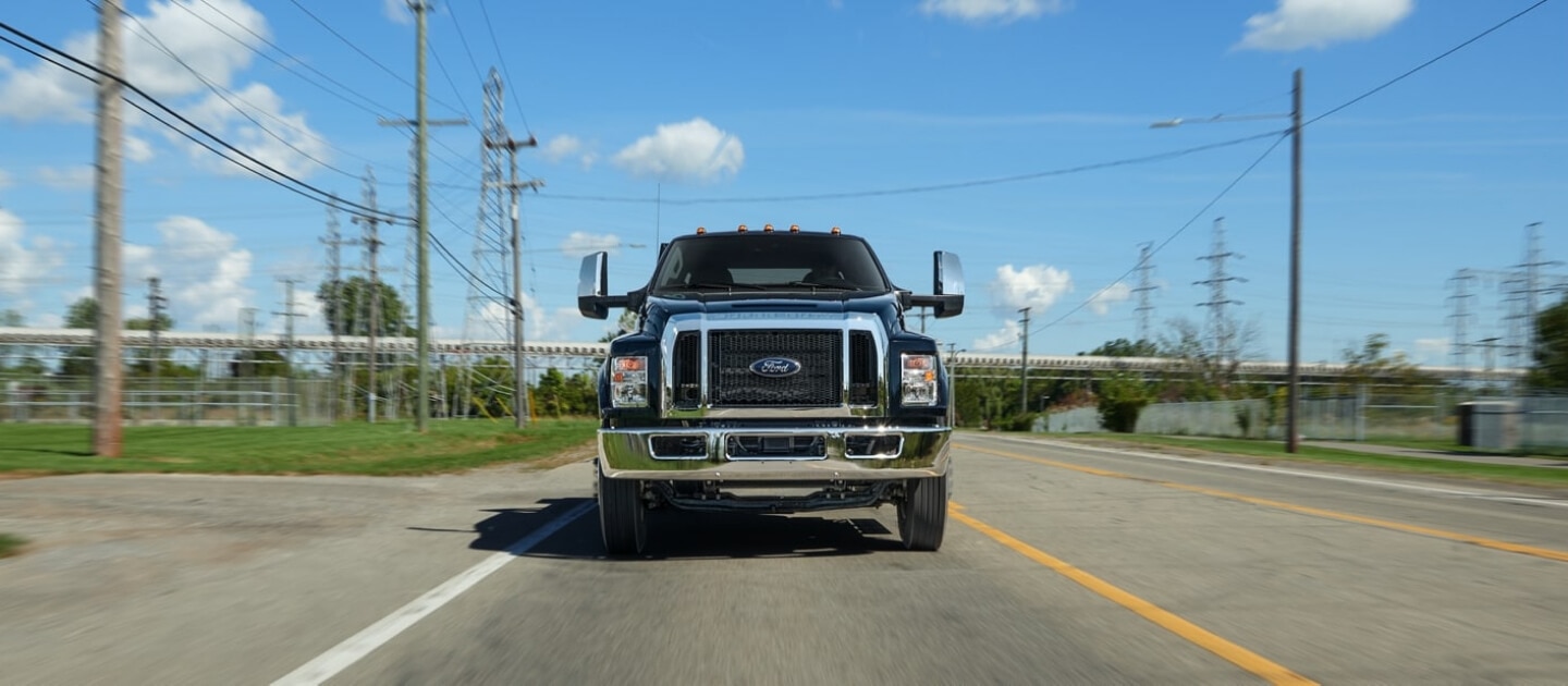 2027 Ford F-750 Crew Cab in Agate Black being driven on road near telephone lines