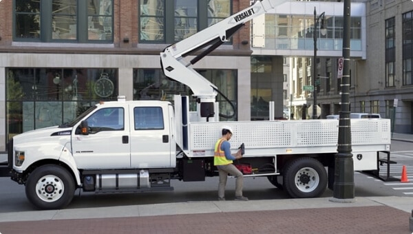 Workers changing city streetlights using 2027 Ford F-750 Crew Cab with aerial lift upfit in Oxford White
