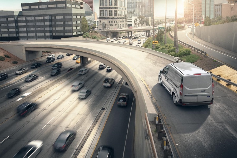 2023 Ford Transit Connect Cargo Van driving on an overpass.