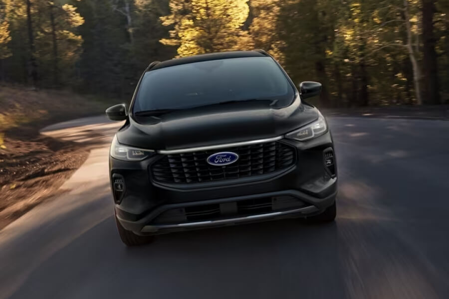 A 2024 Ford Escape seen from the front traveling down a country road