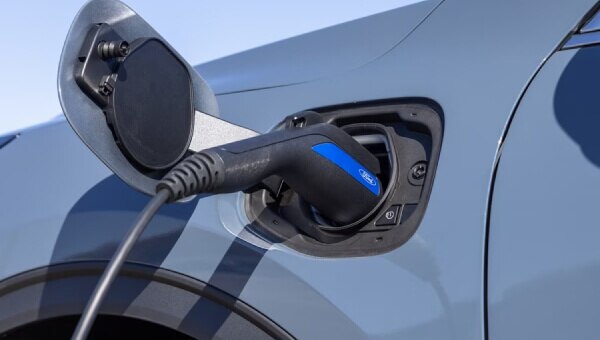 Close-up view of a charging cable plugged into the charge port of a hybrid 2024 Ford Escape