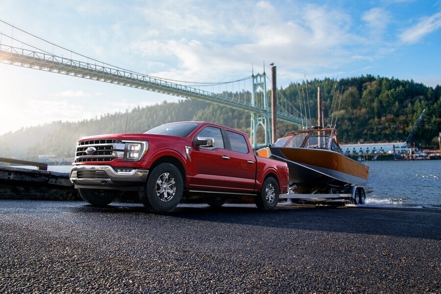 A 2023 Ford F-150® backing a boat into the water.