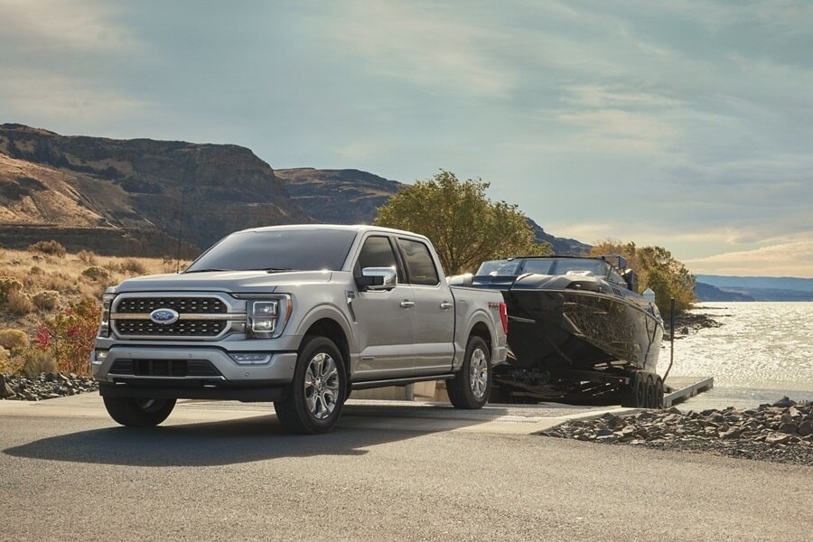 2023 Ford F-150® Platinum in Iconic Silver pulling a boat from a lake